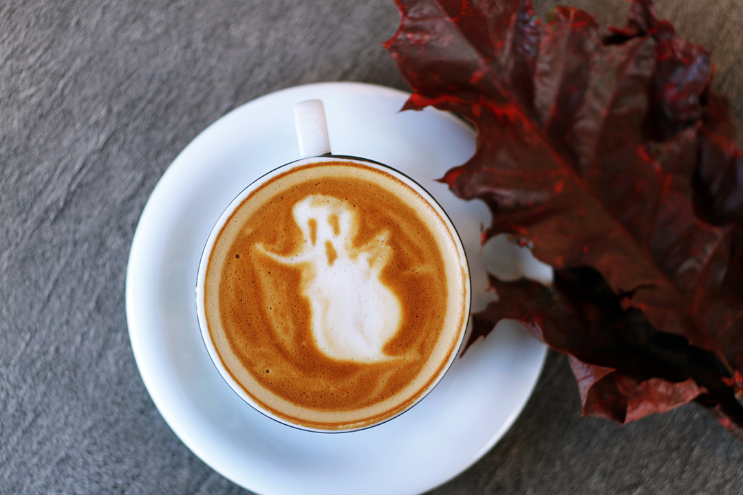 Coffee cup with ghost image in the foam.